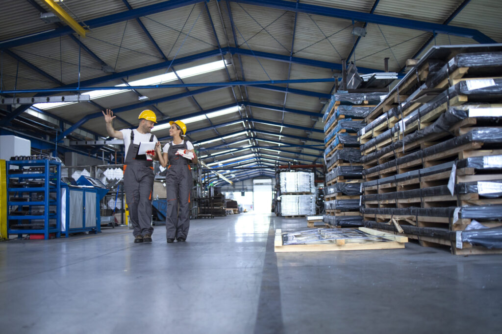 workers factory clothing work yellow helmets walking industrial production room sharing ideas about organization